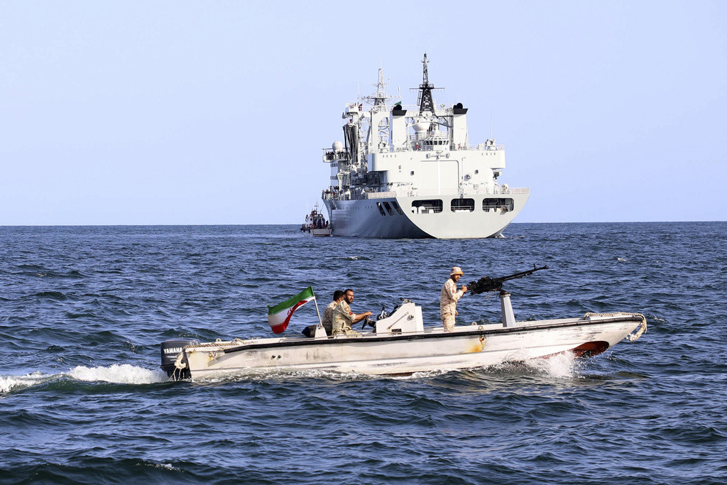 An Iranian military boat patrols as a warship enters the Iranian waters prior to start of a joint naval drill of Iran, Russia and China in the Indian Ocean