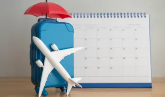 Airplane, suitcase, umbrella and white calendar