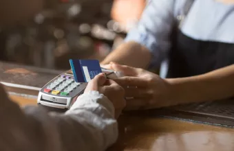 Πελάτης καταστήματος περνά την κάρτα του από POS 