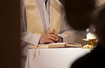 Catholic priest holding hands