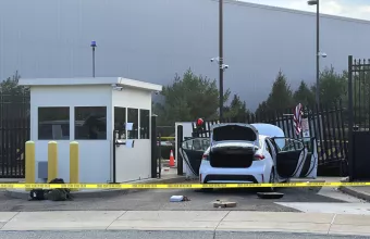 FBI officials inspect a car that rammed into a gate at the FBI building in Pittsburgh