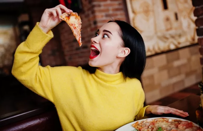 Γυναίκα τρώει πίτσα 