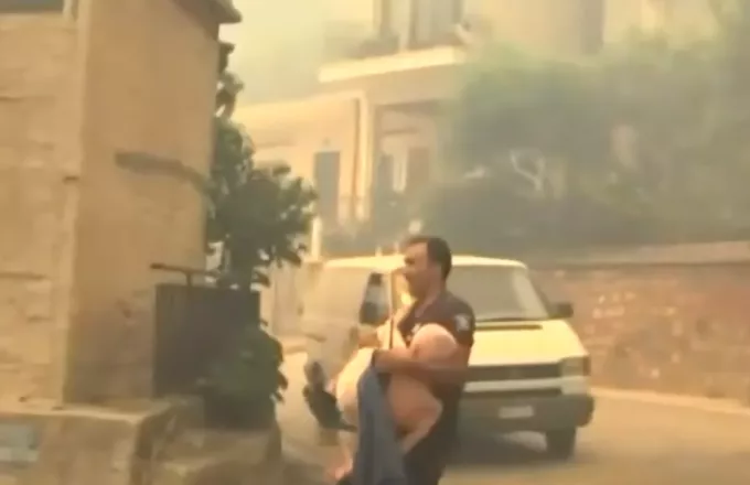 Φωτιά στην Πάτρα: Αστυνομικός απομακρύνει ηλικιωμένο παίρνοντας τον αγκαλιά