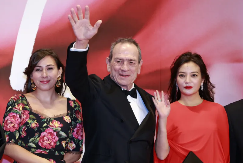  Tommy Lee Jones, center, waves for fans with his daughter Victoria Jones, left, and Jury Zhao Wei 