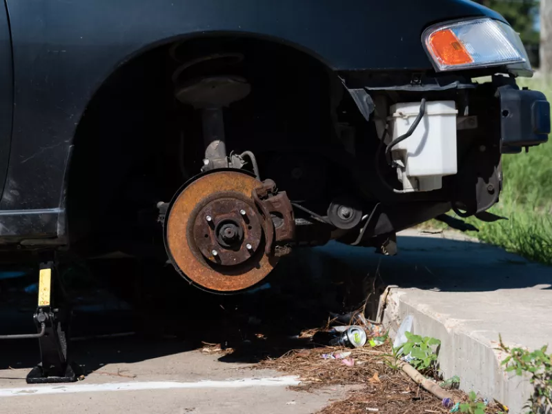 Close-up car with missing left front wheel