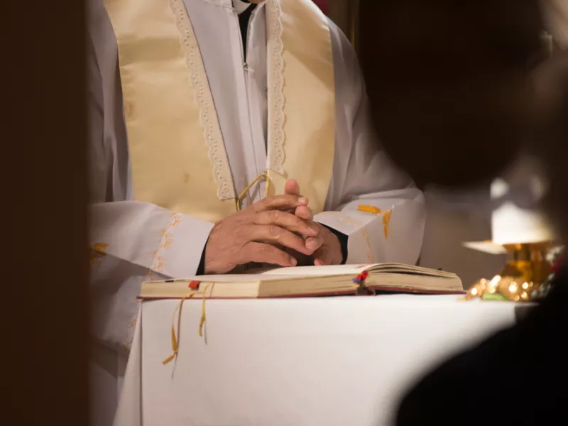 Catholic priest holding hands