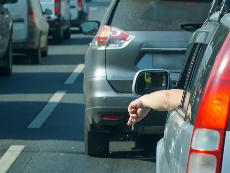 cigarette sticking out of a car windo