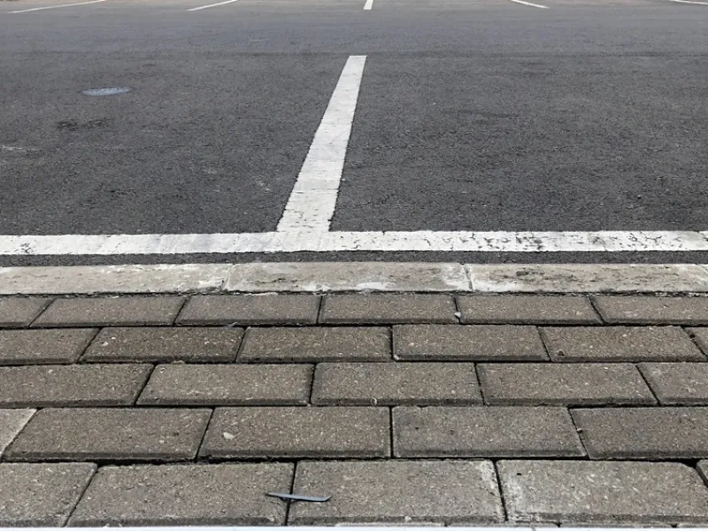 white painted dividing lines on a dark asphalt parking lot