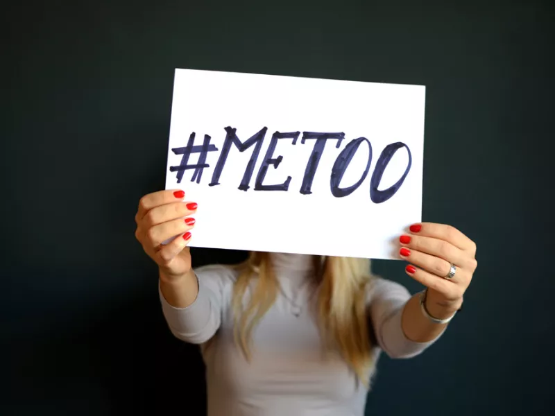 Γυναίκα κρατάει χαρτί που γράφει Metoo